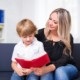 A boy reading a book with his mom